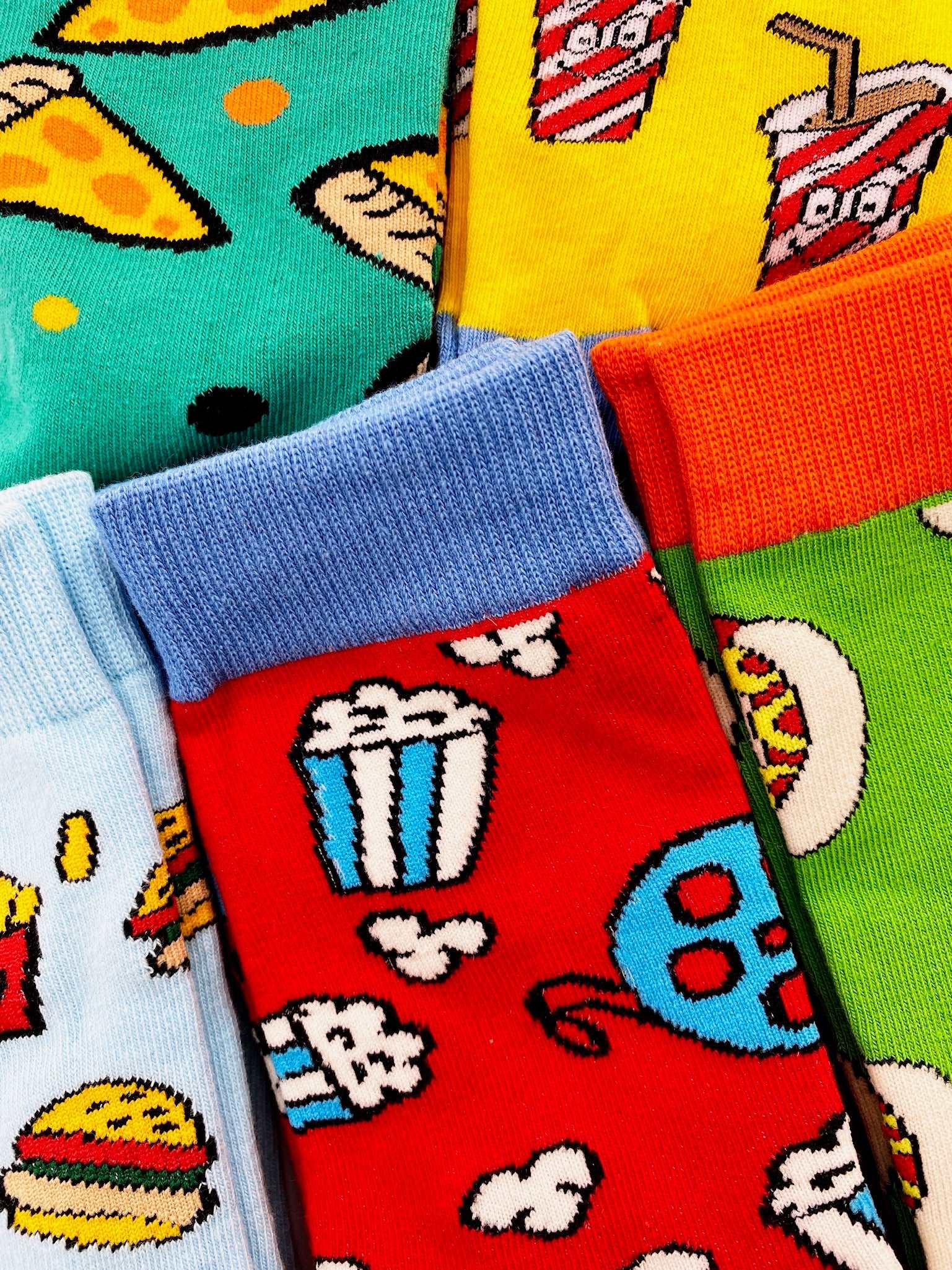 5 colourful pairs of food socks featuring burgers & fries, pizza slices, popcorn, hot dogs and fizzy pop