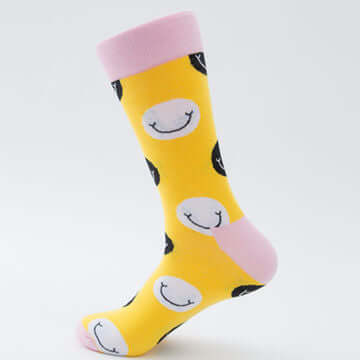 A pair of yellow socks with pale pink cuffs, heels and toes and black and white smiley face motifs,