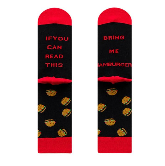 Black socks with red toes, heels and cuffs. Slogan on the bottom of the feet reads "if you can read this, bring me hamburger". Part of a foodie 3 pair gift box.